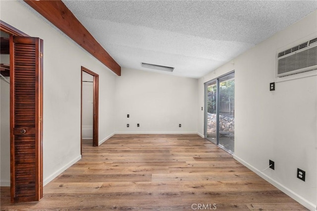 1204 San Jacinto, Redlands, CA 92373 - empty room with a textured ceiling, wood finished floors, a wall mounted air conditioner, and beam ceiling
