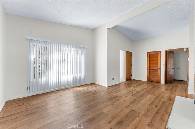 1204 San Jacinto, Redlands, CA 92373 - unfurnished living room featuring light wood-style flooring, vaulted ceiling, and a textured ceiling