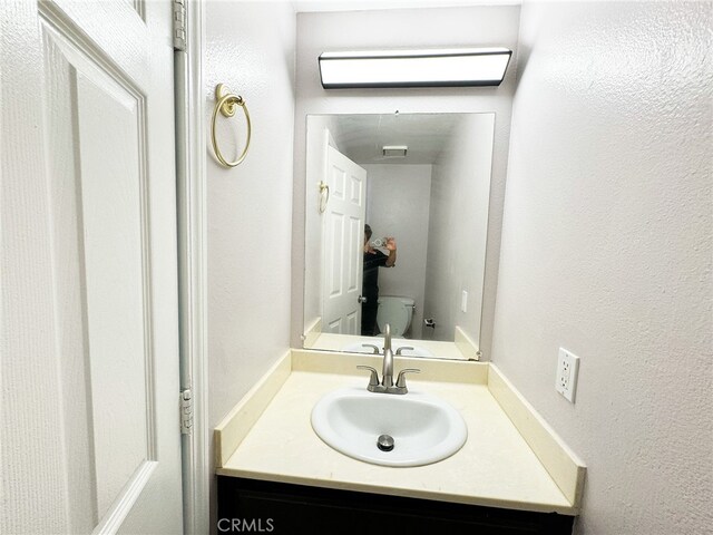 25180 5th St Unit 213, San Bernardino, CA 92410 - half bathroom featuring vanity and a textured wall