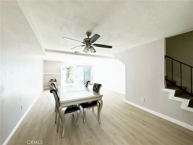 25180 5th St Unit 213, San Bernardino, CA 92410 - dining area with wood finished floors, a textured ceiling, ceiling fan, and stairs