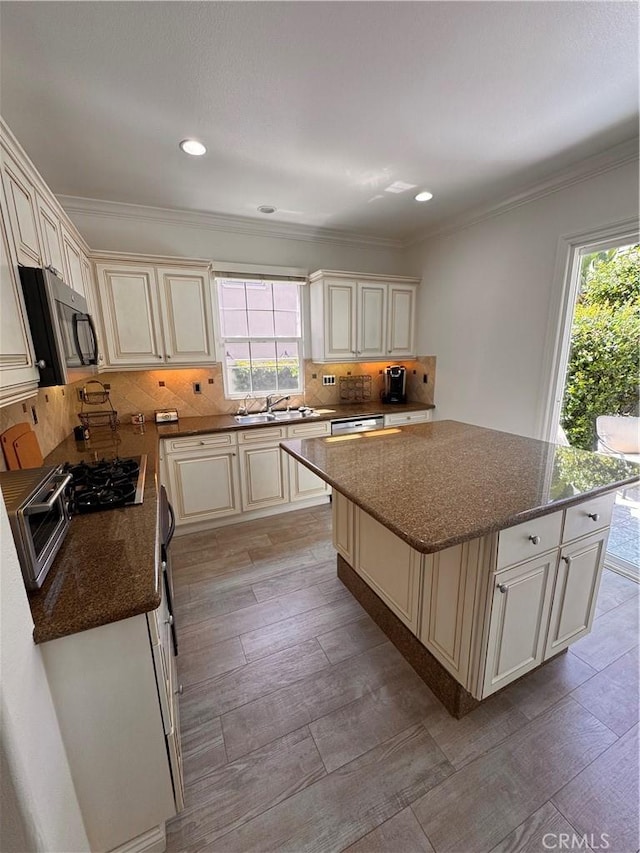 44 Arcata, Irvine, CA 92602 - kitchen with stainless steel microwave, cream cabinets, decorative backsplash, dark stone counters, and recessed lighting
