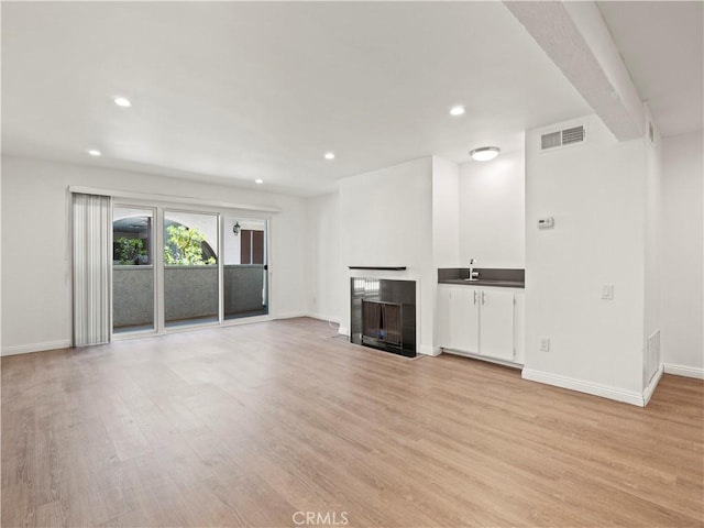 5334 Lindley Ave Unit 125, Encino, CA 91316 - unfurnished living room with light wood finished floors, a fireplace with flush hearth, and recessed lighting