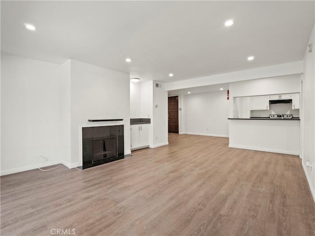 5334 Lindley Ave Unit 125, Encino, CA 91316 - unfurnished living room featuring light wood finished floors, recessed lighting, and a tile fireplace