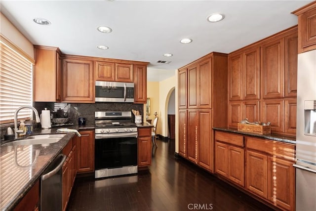 5266 Bluff St, Norco, CA 92860 - kitchen featuring appliances with stainless steel finishes, brown cabinetry, dark wood finished floors, recessed lighting, and tasteful backsplash