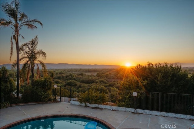 5266 Bluff St, Norco, CA 92860 - pool at dusk featuring a mountain view and a patio