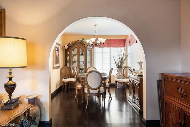5266 Bluff St, Norco, CA 92860 - dining area featuring arched walkways, dark wood-type flooring, and a chandelier