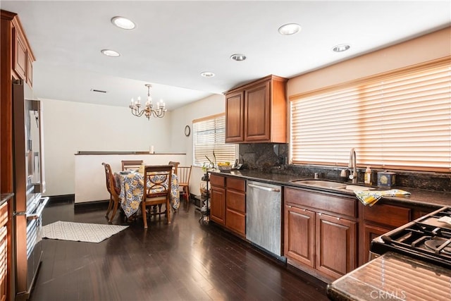 5266 Bluff St, Norco, CA 92860 - kitchen featuring appliances with stainless steel finishes, a chandelier, brown cabinets, dark wood-style flooring, and decorative backsplash