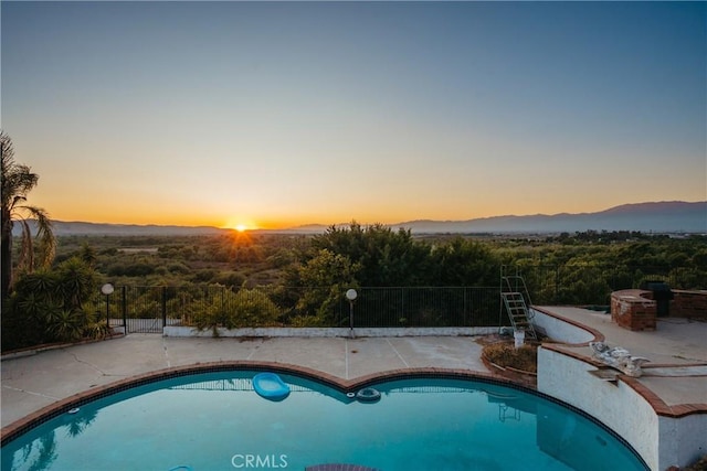 5266 Bluff St, Norco, CA 92860 - pool at dusk with an outdoor pool, a mountain view, and a patio area