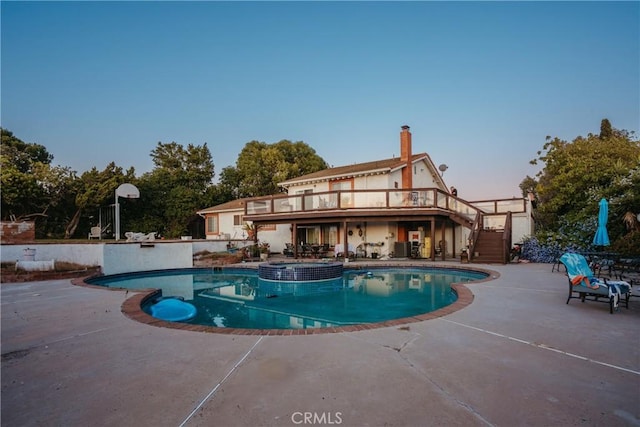 5266 Bluff St, Norco, CA 92860 - pool at dusk with stairs, a patio area, a pool with connected hot tub, and a wooden deck