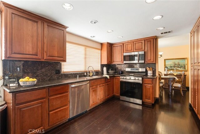 5266 Bluff St, Norco, CA 92860 - kitchen with appliances with stainless steel finishes, tasteful backsplash, dark wood finished floors, brown cabinets, and recessed lighting