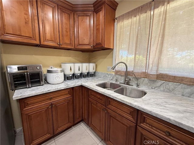 11057 Dudley Way, Stanton, CA 90680 - kitchen featuring brown cabinetry, light marble finish flooring, and light stone counters