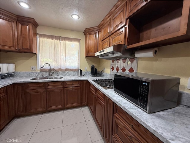 11057 Dudley Way, Stanton, CA 90680 - kitchen featuring stainless steel appliances, under cabinet range hood, a textured ceiling, backsplash, and light marble finish flooring