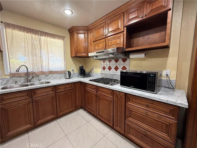 11057 Dudley Way, Stanton, CA 90680 - kitchen featuring under cabinet range hood, stainless steel gas cooktop, a textured ceiling, decorative backsplash, and light marble finish flooring