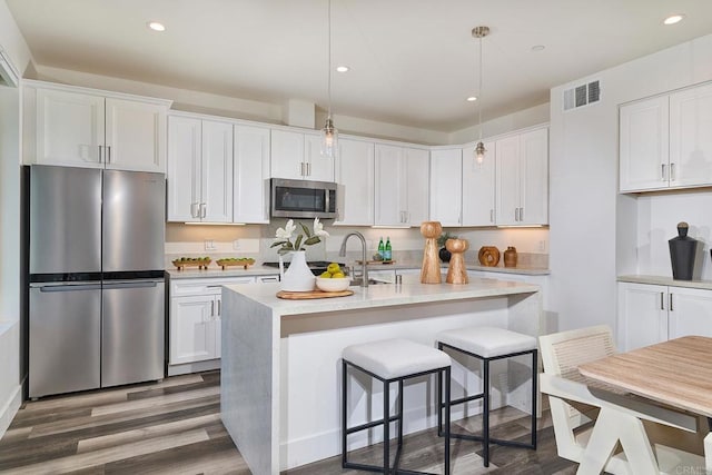 1506 Alvarado St, Oceanside, CA 92054 - kitchen featuring appliances with stainless steel finishes, wood finished floors, light countertops, white cabinets, and recessed lighting