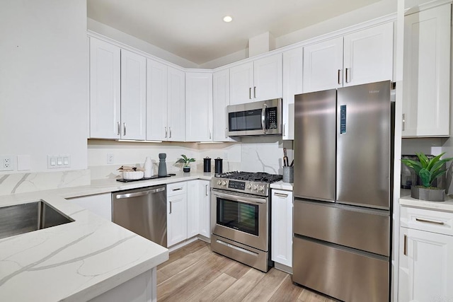 1506 Alvarado St, Oceanside, CA 92054 - kitchen with stainless steel appliances, white cabinets, light wood-type flooring, light stone countertops, and recessed lighting