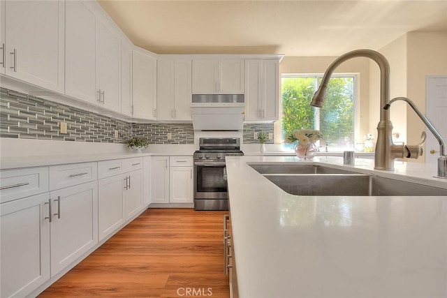 149 E Saint Andrews St, Ontario, CA 91761 - kitchen featuring stainless steel stove, under cabinet range hood, white cabinets, and backsplash