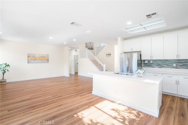 149 E Saint Andrews St, Ontario, CA 91761 - kitchen featuring freestanding refrigerator, light countertops, light wood finished floors, a center island with sink, and recessed lighting