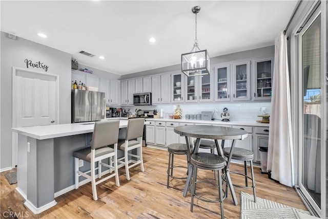 31164 Twilight Vista Dr, Menifee, CA 92584 - kitchen with stainless steel appliances, a kitchen island, a kitchen breakfast bar, light countertops, and recessed lighting