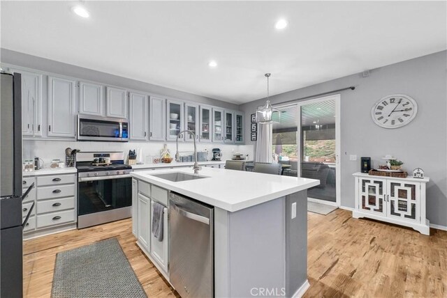 31164 Twilight Vista Dr, Menifee, CA 92584 - kitchen with appliances with stainless steel finishes, light countertops, a center island with sink, recessed lighting, and pendant lighting
