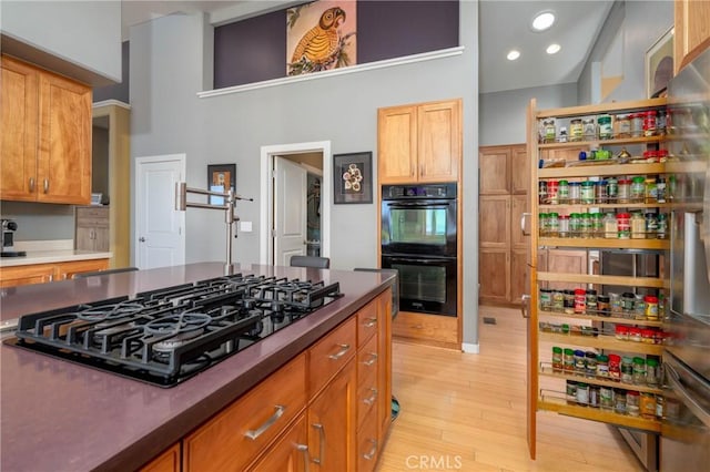 3165 Keeling Ave, Lakeport, CA 95453 - kitchen featuring black appliances, light wood-style flooring, dark countertops, open shelves, and a towering ceiling