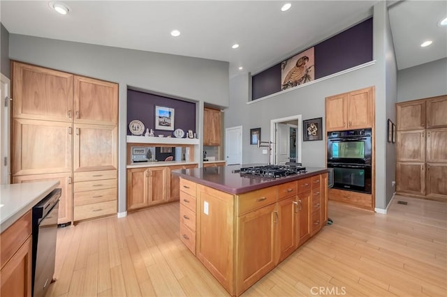 3165 Keeling Ave, Lakeport, CA 95453 - kitchen with a kitchen island, a high ceiling, light wood-style flooring, dark countertops, and stainless steel gas stovetop
