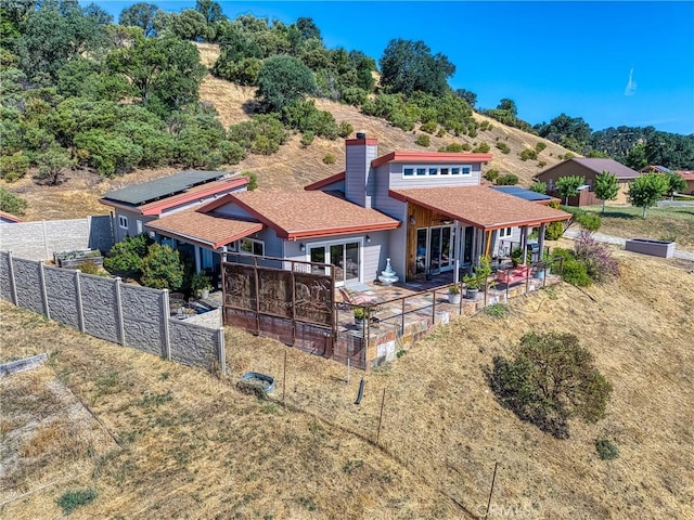 3165 Keeling Ave, Lakeport, CA 95453 - back of house with roof mounted solar panels, a patio area, a shingled roof, and a chimney