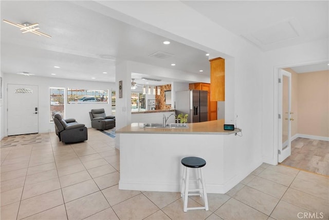 23859 S Rd, Apple Valley, CA 92307 - kitchen with stainless steel fridge with ice dispenser, light tile patterned floors, recessed lighting, a peninsula, and brown cabinets