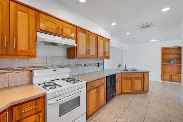 23859 S Rd, Apple Valley, CA 92307 - kitchen with white gas range, dishwasher, under cabinet range hood, brown cabinetry, and tasteful backsplash