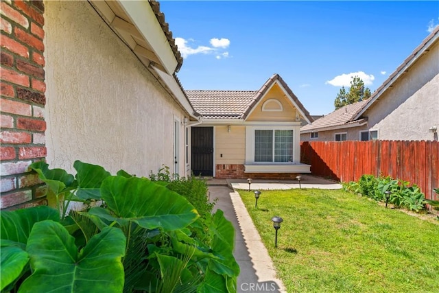 11571 Pinnacle Peak Ct, Rancho Cucamonga, CA 91737 - view of exterior entry with brick siding, a tile roof, and stucco siding