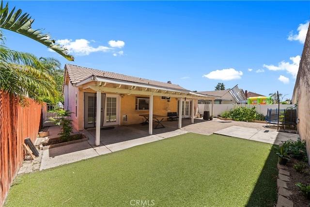 11571 Pinnacle Peak Ct, Rancho Cucamonga, CA 91737 - rear view of property with a fenced backyard, a tile roof, a patio, a trampoline, and stucco siding