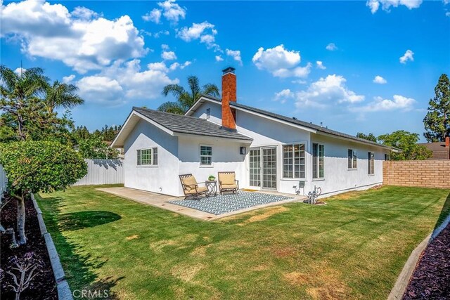 14181 Moore Ct, Irvine, CA 92606 - back of property with a fenced backyard, a patio area, stucco siding, and a chimney