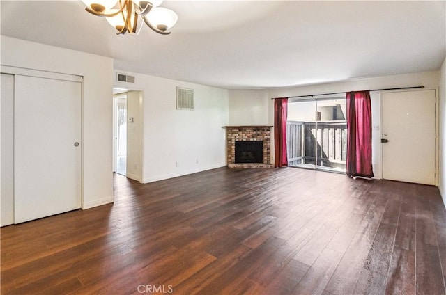 8544 Independence Ave Unit 102, Canoga Park, CA 91304 - unfurnished living room with a chandelier, dark wood-style floors, and a brick fireplace