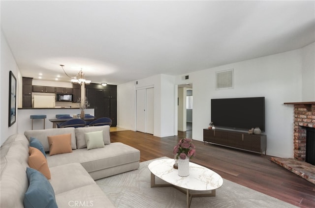 8544 Independence Ave Unit 102, Canoga Park, CA 91304 - living room featuring dark wood-style floors, a chandelier, and a fireplace