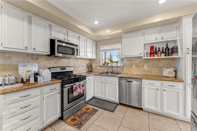 404 Atwood Dr, Corona, CA 92879 - kitchen with appliances with stainless steel finishes, light tile patterned floors, white cabinetry, light stone counters, and backsplash