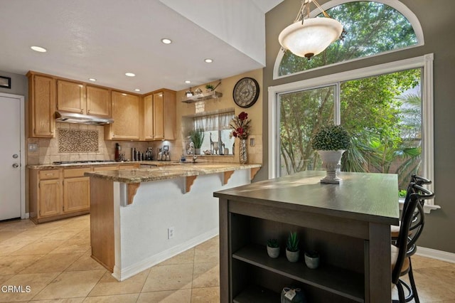 1501 Devonshire Dr, Oxnard, CA 93030 - kitchen featuring open shelves, backsplash, a breakfast bar area, under cabinet range hood, and recessed lighting