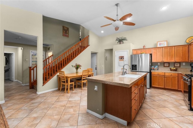 1447 White Cloud Ln, Beaumont, CA 92223 - kitchen with ceiling fan, range, stainless steel refrigerator with ice dispenser, light tile patterned floors, and high vaulted ceiling