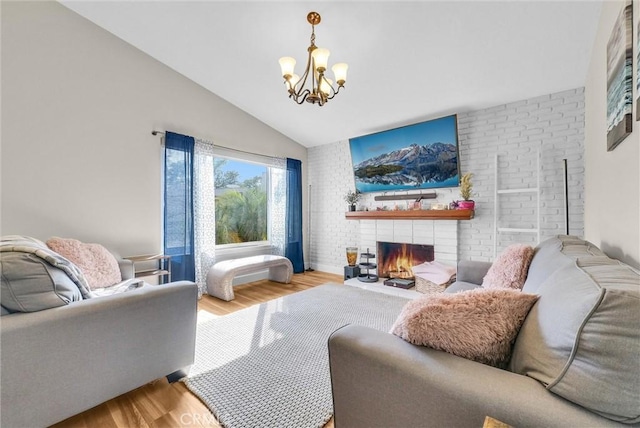 12312 Marmont Pl, Moreno Valley, CA 92557 - living room featuring wood finished floors, vaulted ceiling, a chandelier, and a brick fireplace