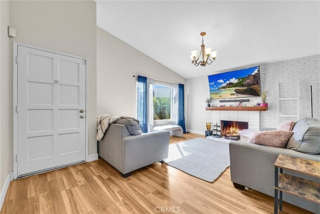 12312 Marmont Pl, Moreno Valley, CA 92557 - living area with a chandelier, lofted ceiling, light wood-type flooring, a brick fireplace, and brick wall
