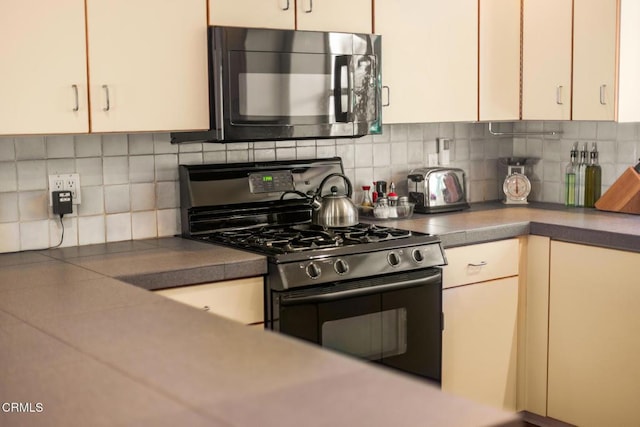 840 Fairview Rd, Ojai, CA 93023 - kitchen with black microwave, stainless steel gas stove, backsplash, and dark countertops
