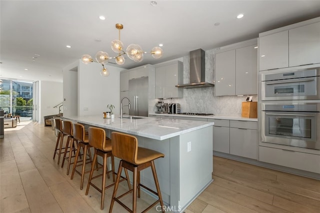 3306 Via Oporto, Newport Beach, CA 92663 - kitchen featuring wall chimney exhaust hood, tasteful backsplash, gray cabinetry, modern cabinets, and light wood-style floors