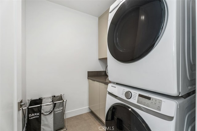 3306 Via Oporto, Newport Beach, CA 92663 - washroom featuring stacked washer and clothes dryer, cabinet space, and light tile patterned floors