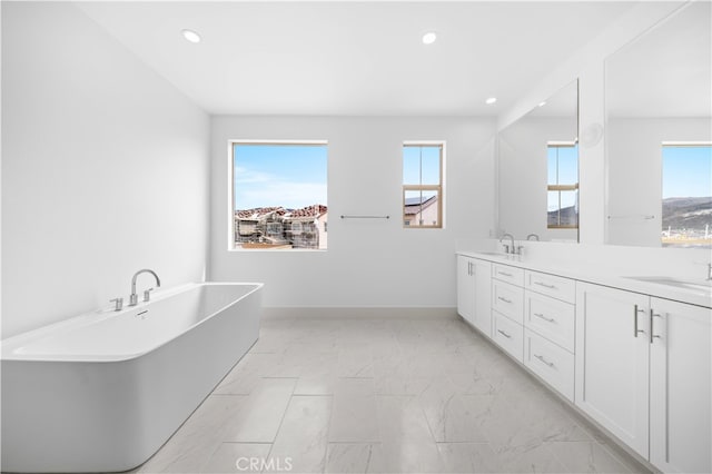 312 Brimwood, Irvine, CA 92618 - full bath with marble look tiles, a freestanding tub, double vanity, plenty of natural light, and recessed lighting