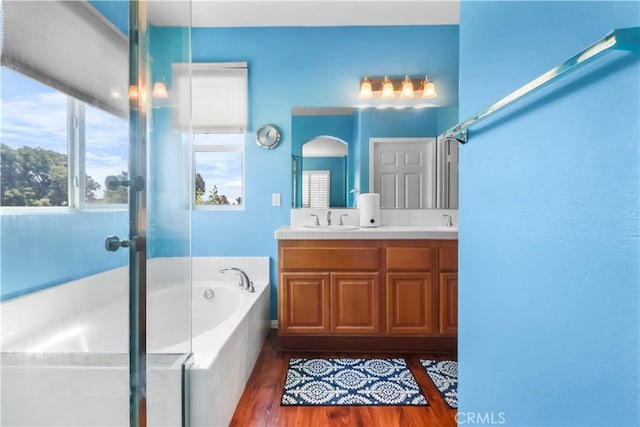 9044 Sylmar Ave, Panorama City, CA 91402 - bathroom with a garden tub, wood finished floors, and double vanity