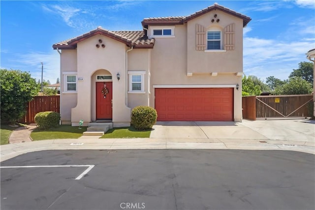 9044 Sylmar Ave, Panorama City, CA 91402 - mediterranean / spanish house with stucco siding, a tiled roof, a garage, a gate, and driveway