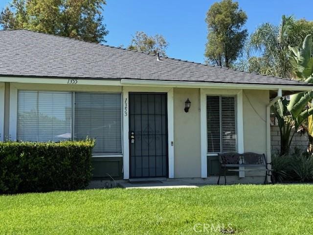 1353 E Fairgrove Ave Unit 293, West Covina, CA 91792 - entrance to property featuring a yard, roof with shingles, and stucco siding