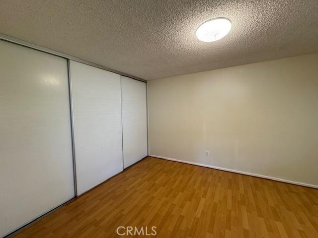 1353 E Fairgrove Ave Unit 293, West Covina, CA 91792 - unfurnished bedroom with wood finished floors, a closet, and a textured ceiling