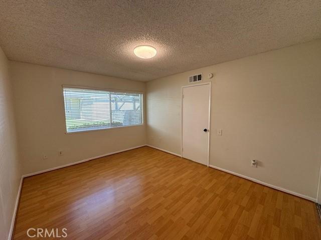 1353 E Fairgrove Ave Unit 293, West Covina, CA 91792 - spare room featuring wood finished floors and a textured ceiling