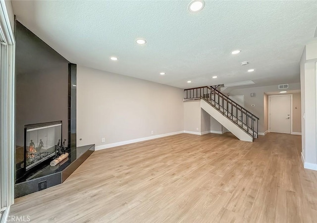 19237 Index St Unit 5, Porter Ranch, CA 91326 - unfurnished living room featuring stairway, light wood-style floors, a textured ceiling, and recessed lighting
