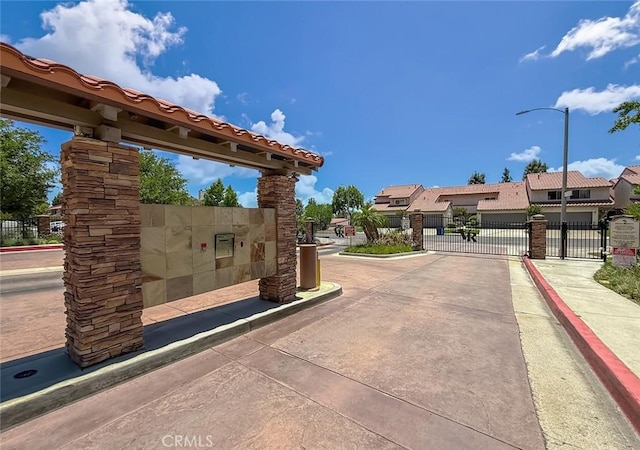 19237 Index St Unit 5, Porter Ranch, CA 91326 - view of concrete road featuring curbs, a gate, a gated entry, street lighting, and a residential view
