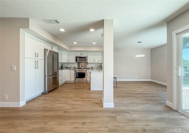 19237 Index St Unit 5, Porter Ranch, CA 91326 - kitchen with high quality appliances, light wood-style flooring, white cabinets, light countertops, and recessed lighting